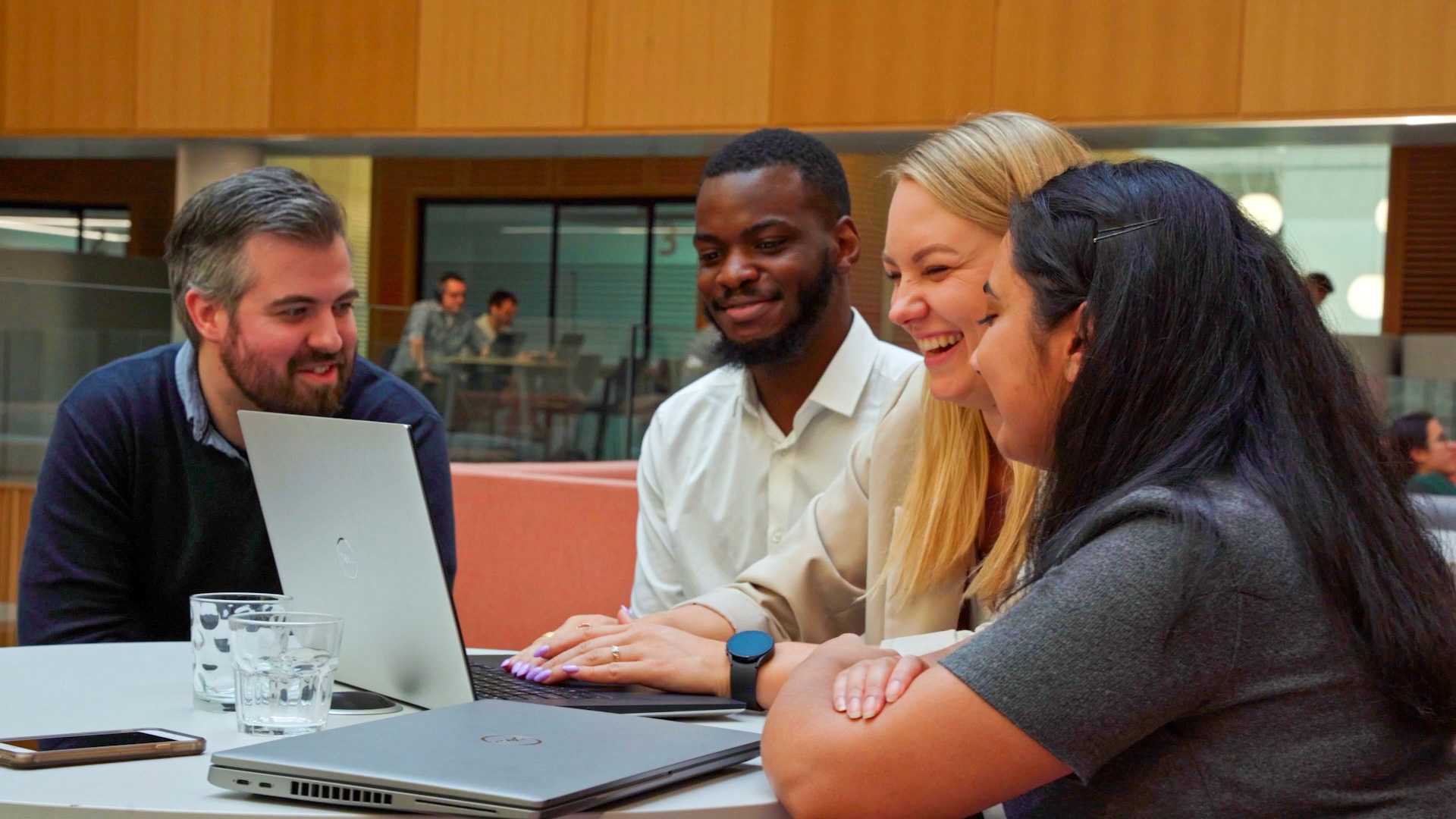 A group of people gathered around a laptop.