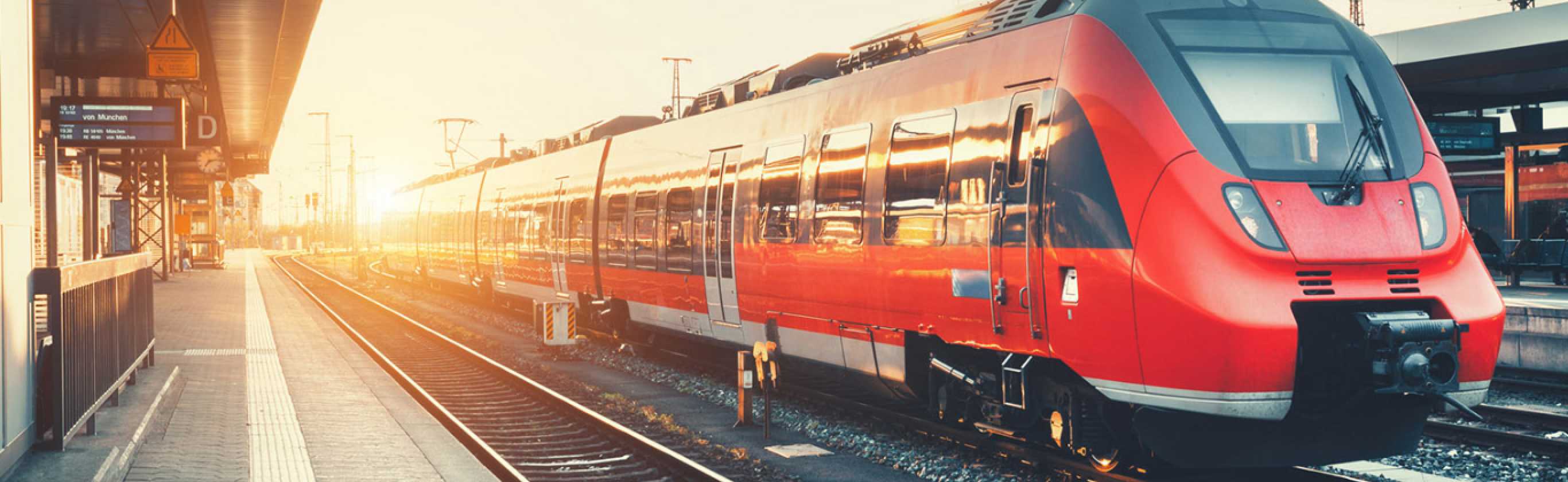 Train in station with sunset background.